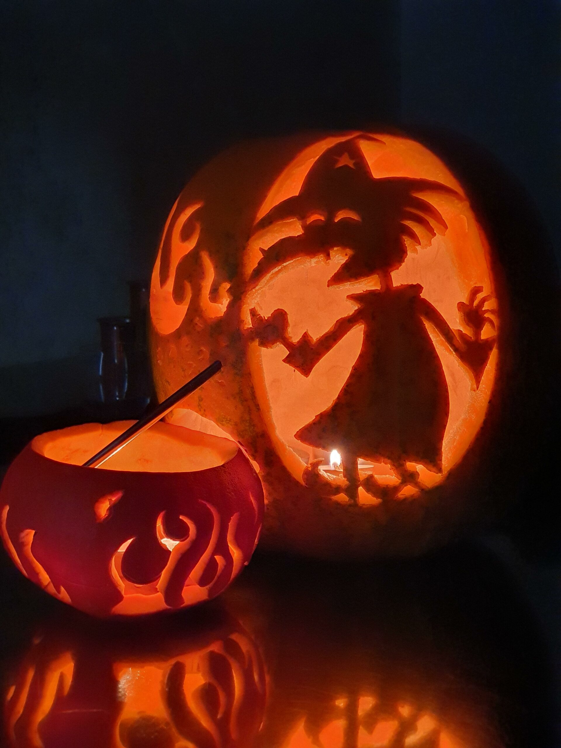Pumpkins carved to look like a witch and a cauldron 