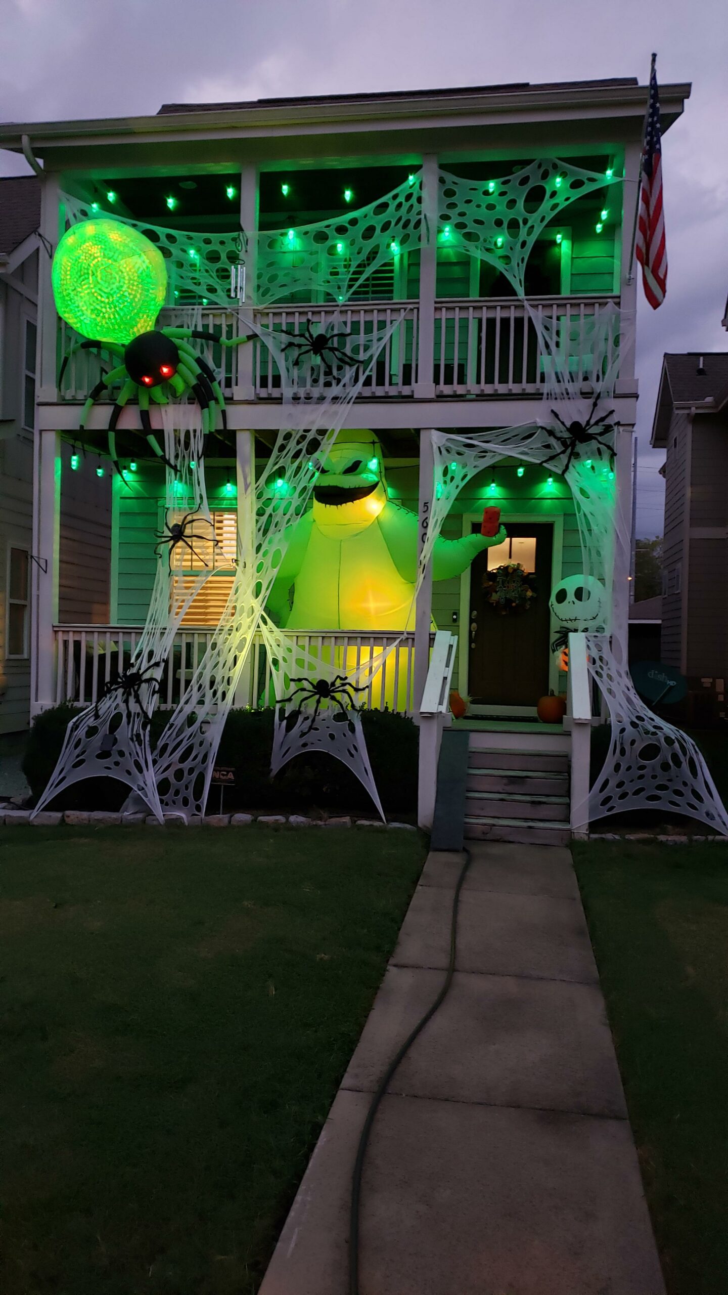 outside of house decorated with giant spiders and webs for Halloween