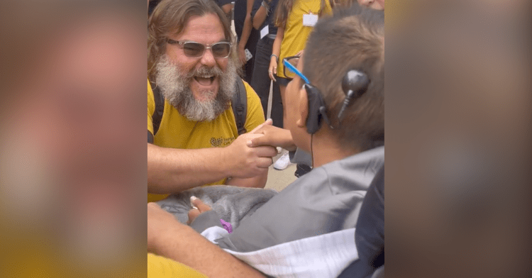 jack black serenading abraham while holding his hand.