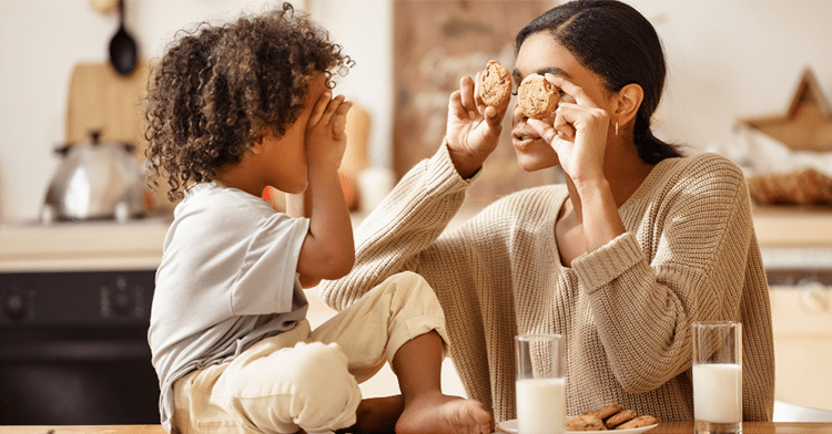 mom and child holding up cookies to their eyes in the kitchen
