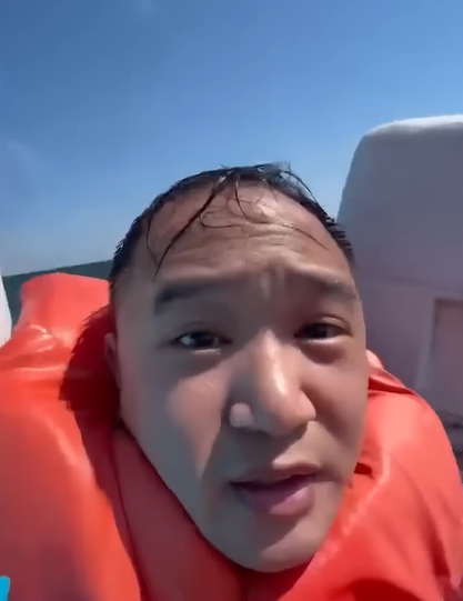 stranded fisherman wearing life vest at sea.