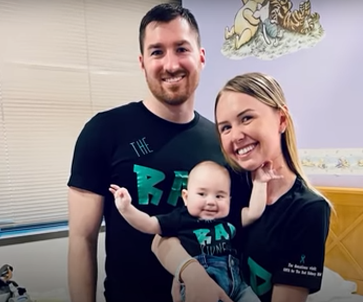 Proud Parents, Branden Williams and Austyn Evans, Pose with Baby Conrad in His Nursery at Home. Austyn is Holding Conrad and the Whole Family is Smiling.