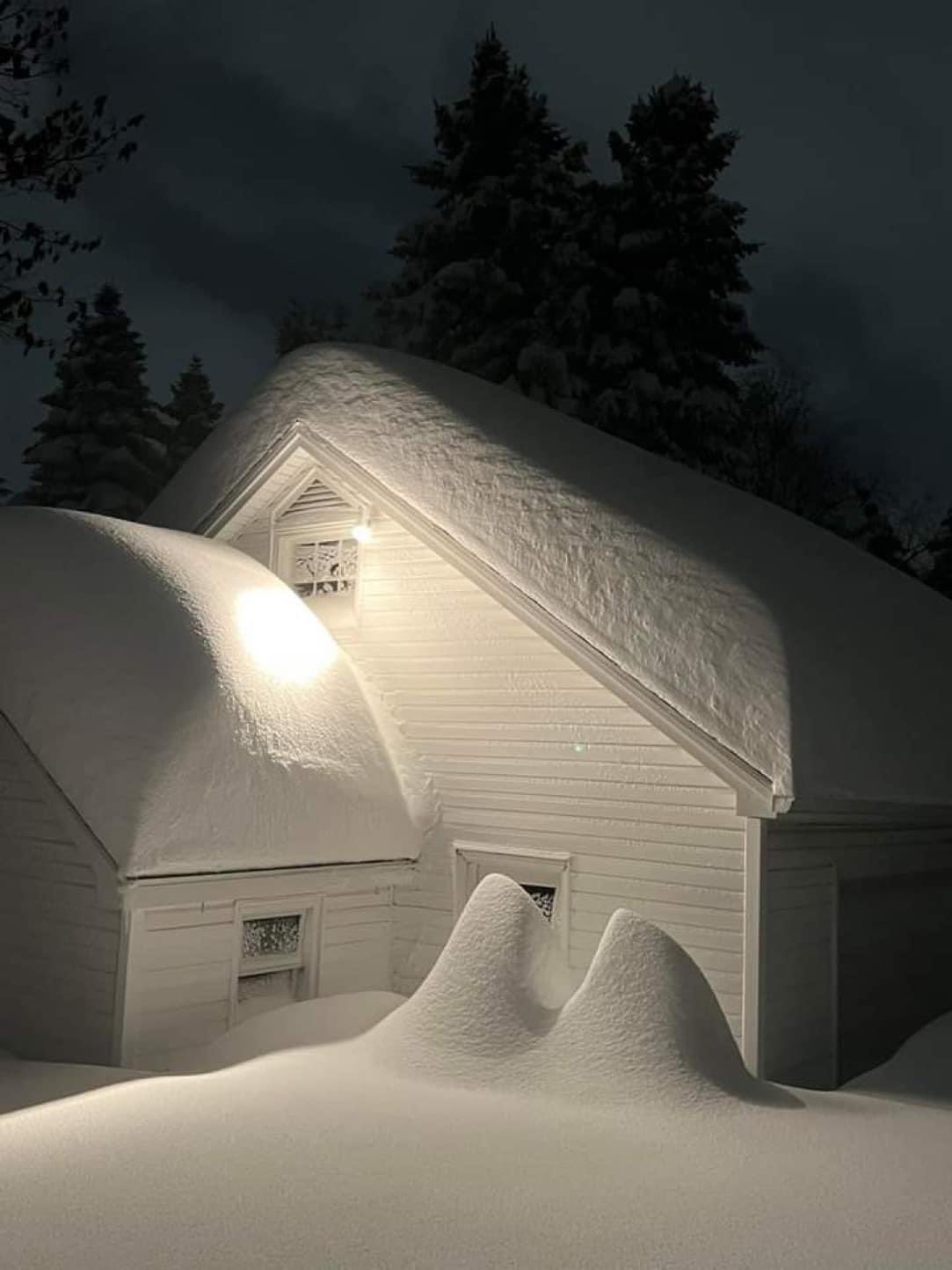 cottage almost buried in fluffy white snow near Buffalo, NY.