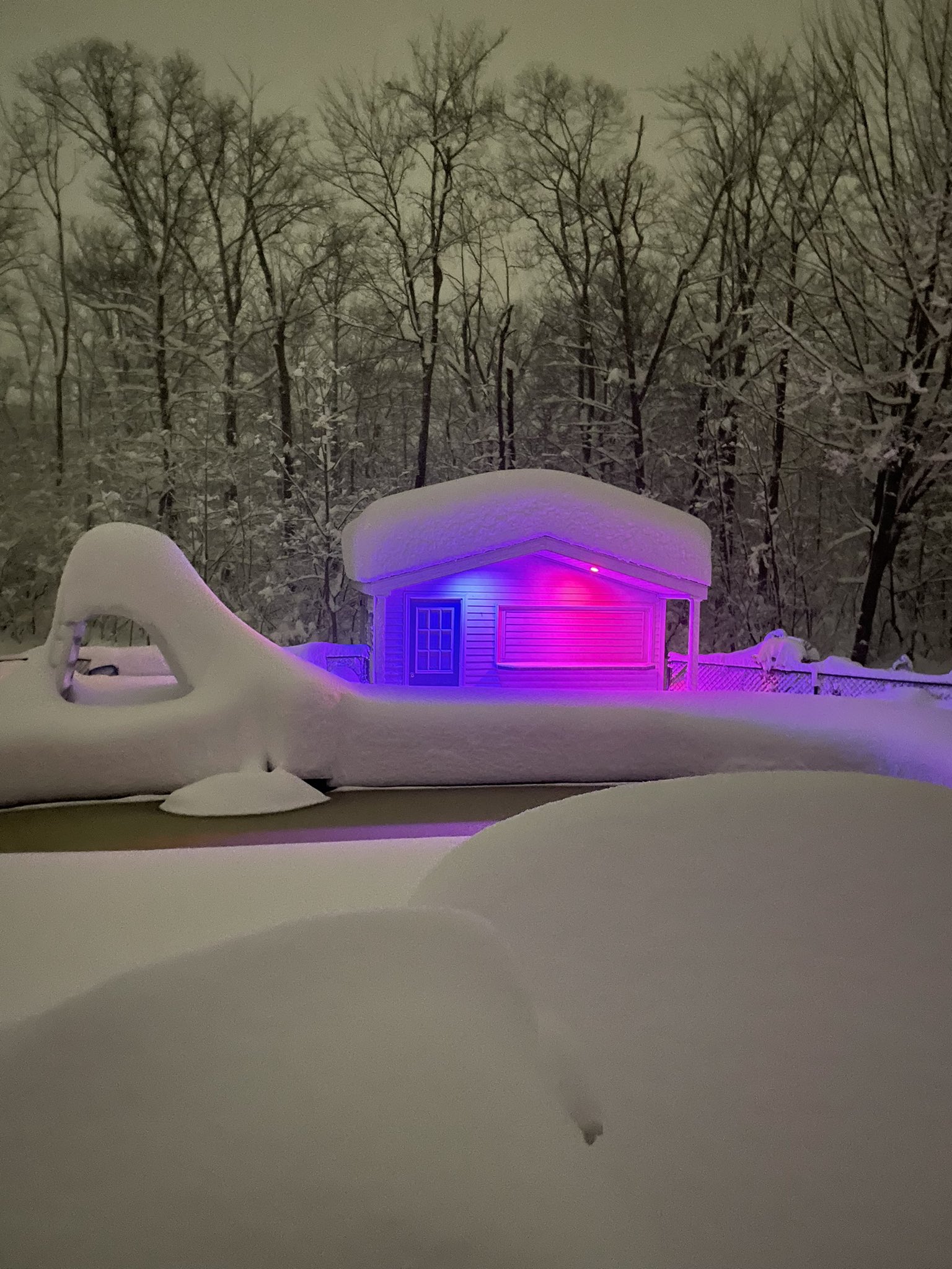 pool house lit up with Buffalo Bills colors after huge snowstorm.