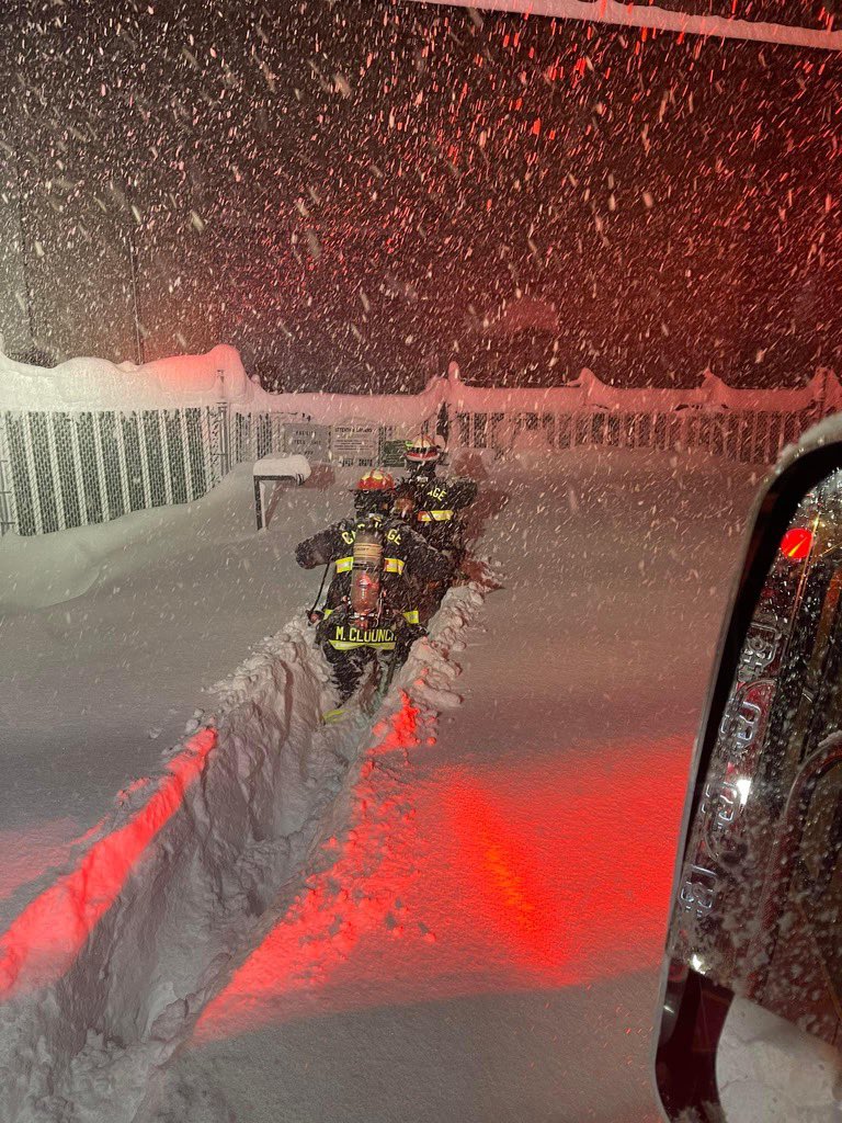 Firefighters from Carthage, NY struggle through waist-deep snow to help caller in NY.