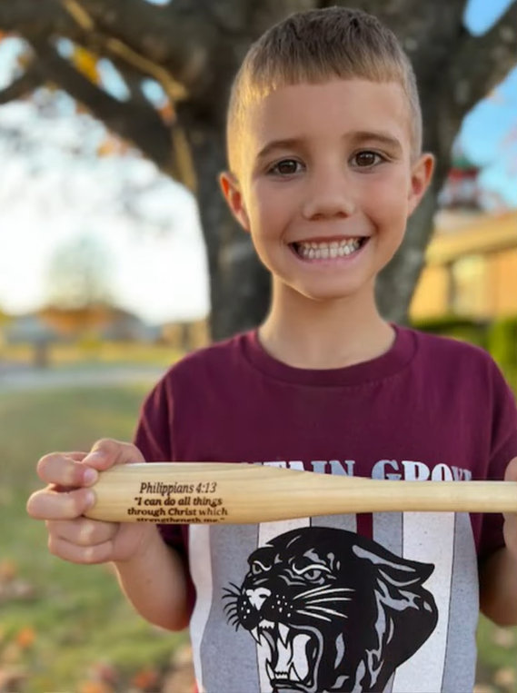 Kason Johnson holding handmade bat made by Todd Huyley