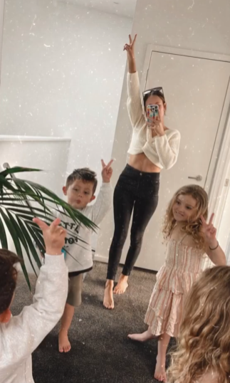 A mirror reflection of Samantha, Kaelin, and Haidyn is shown in the picture. Samantha holds her phone to snap the photo as all three of them make the peace sign,