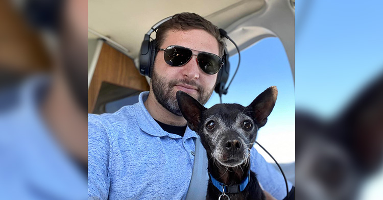 Pet Rescue Pilots pilot and senior rescue dog posing for a photo from inside a plane.