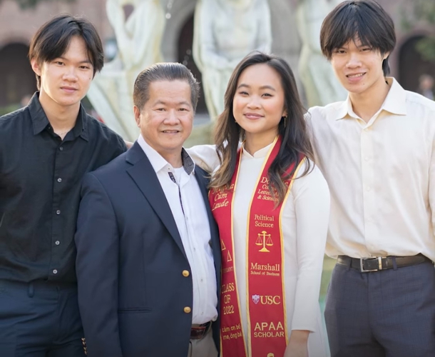 Four members of a family pose for a photo after graduating at the same time.
