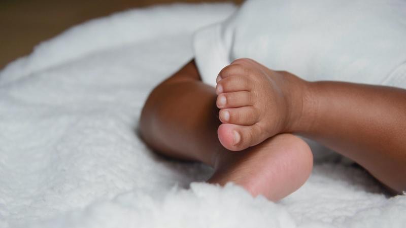 Closeup of baby feet on a white blanket.