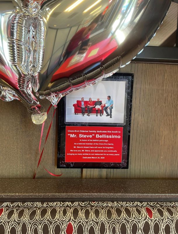 A plaque is shown dedicating a booth at a Florida Chick-fil-A restaurant to a beloved customer named Mr. Steve.
