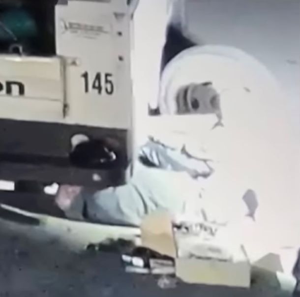 A man is positioned under a truck.