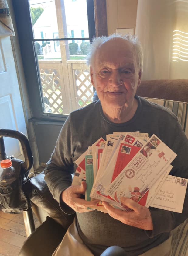 George Dowling holding an armful of Christmas cards from strangers.