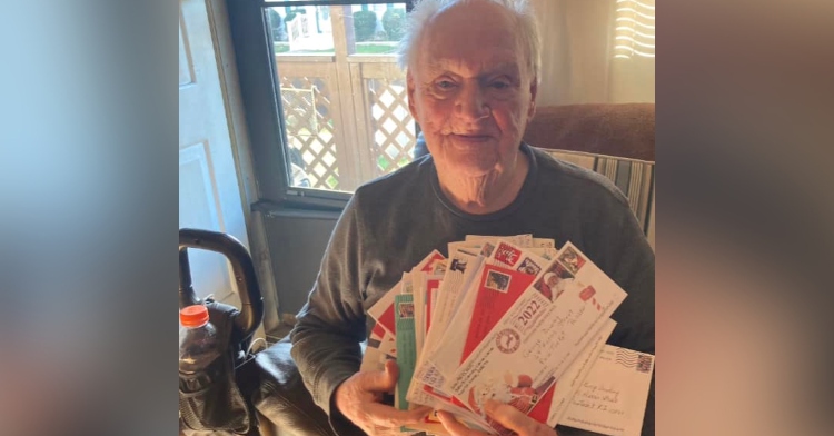 George Dowling holds up an armful of Christmas cards he received from strangers.