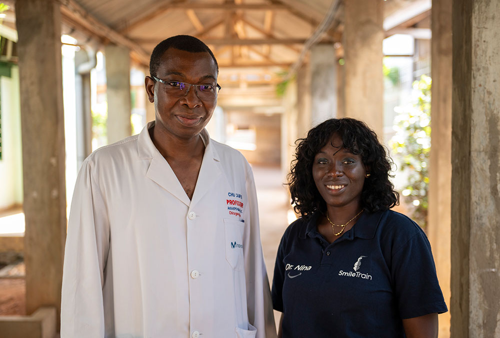 Dr. Grégoire Akakpo-Numado smiling as he poses with a woman named Dr. Nina who is wearing a Smile Train shirt.