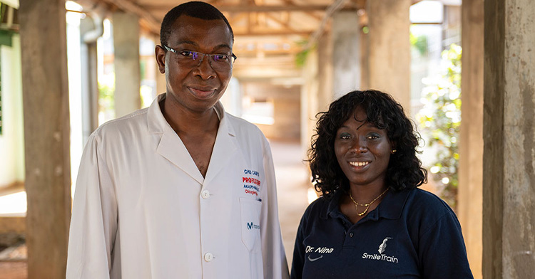 Dr. Grégoire Akakpo-Numado smiling as he poses with a woman named Dr. Nina who is wearing a Smile Train shirt.