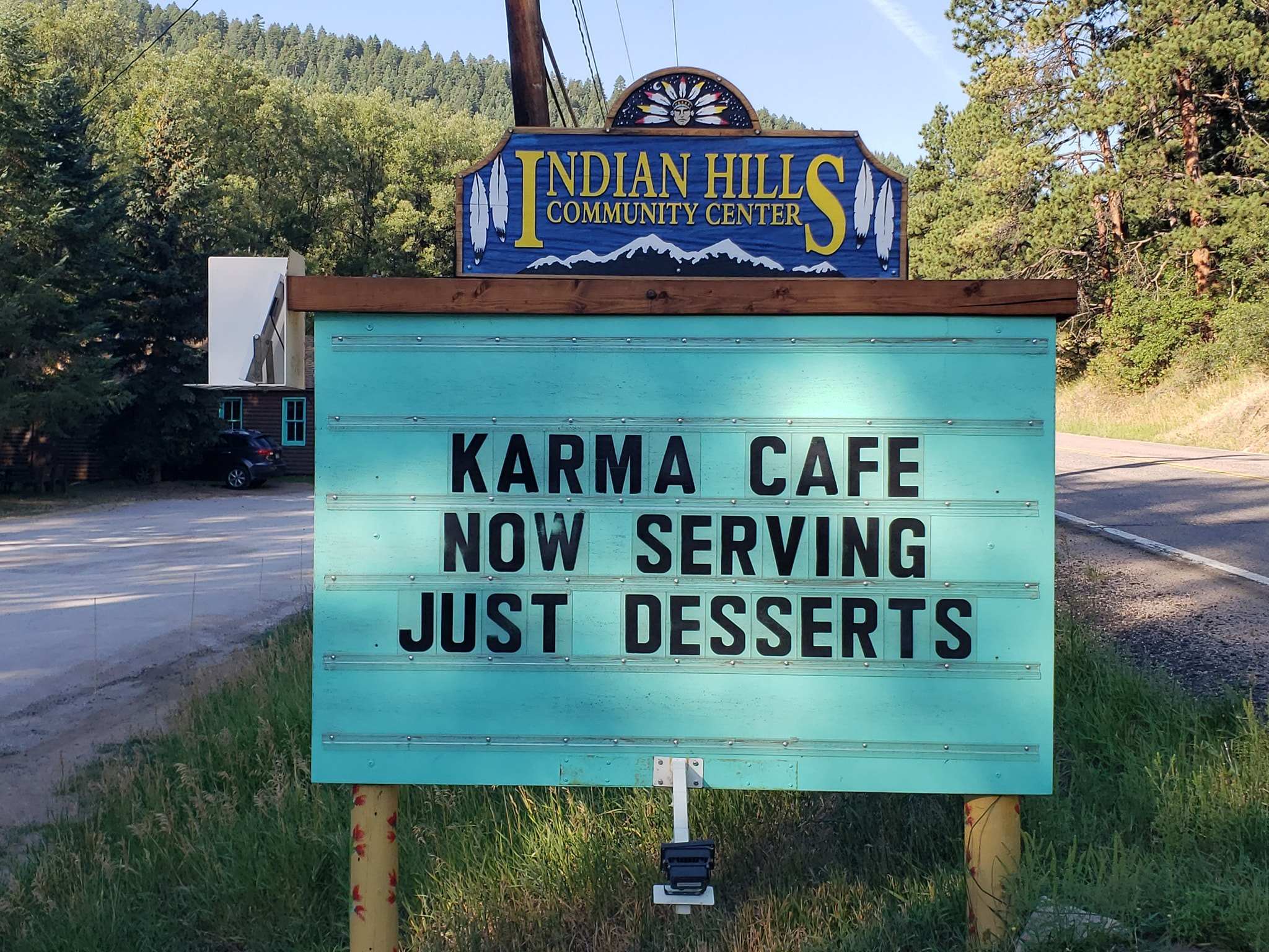 community sign that says "Karma cafe now serving just desserts"