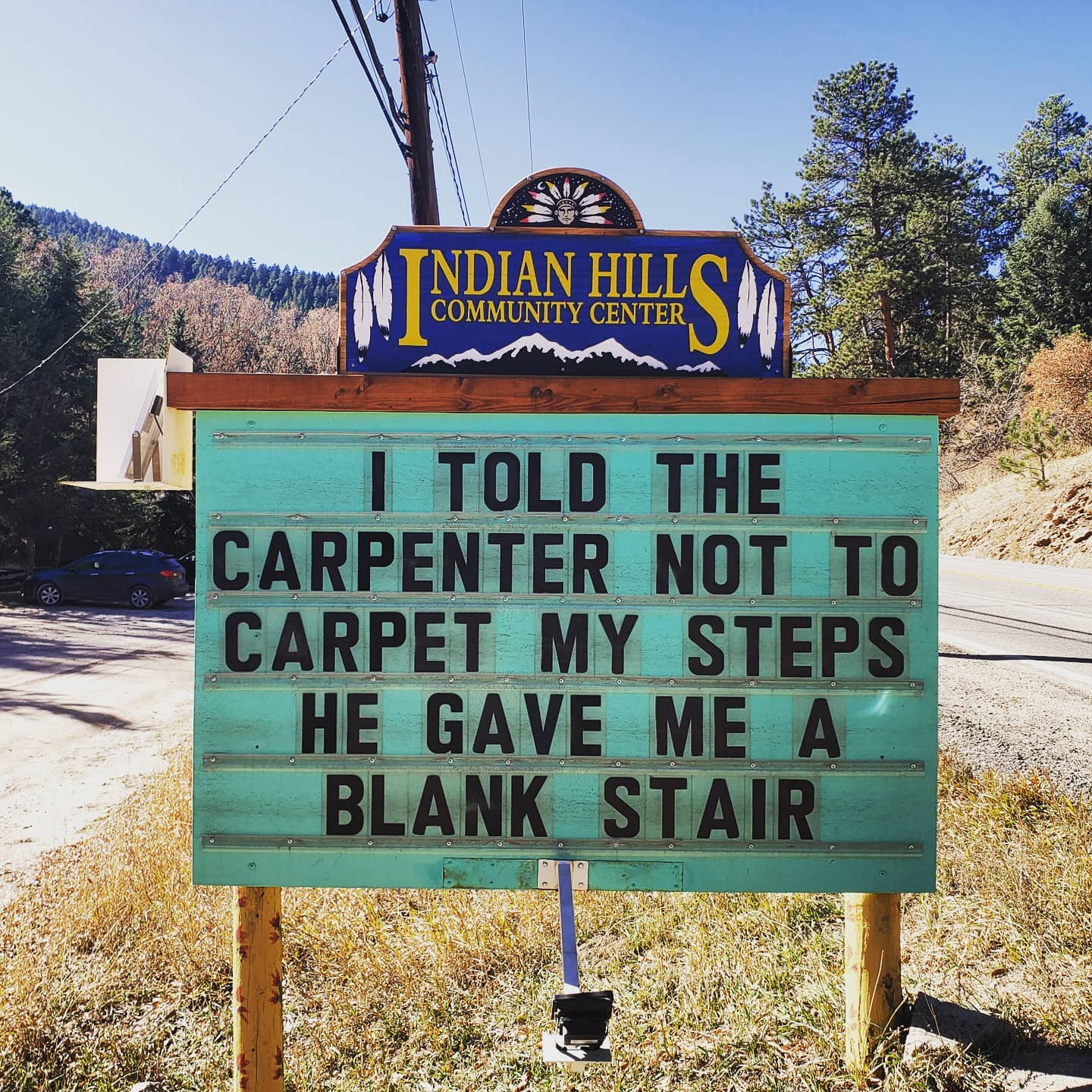 community sign that says: "I told the carpenter not to carpet my steps. he gave me a blank stare."
