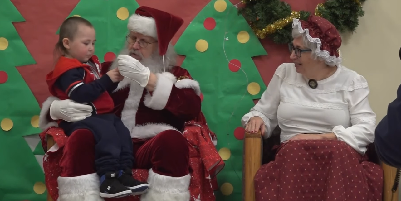 Santa and Mrs. Claus chat with a little boy in Nuiqsut, Alaska.