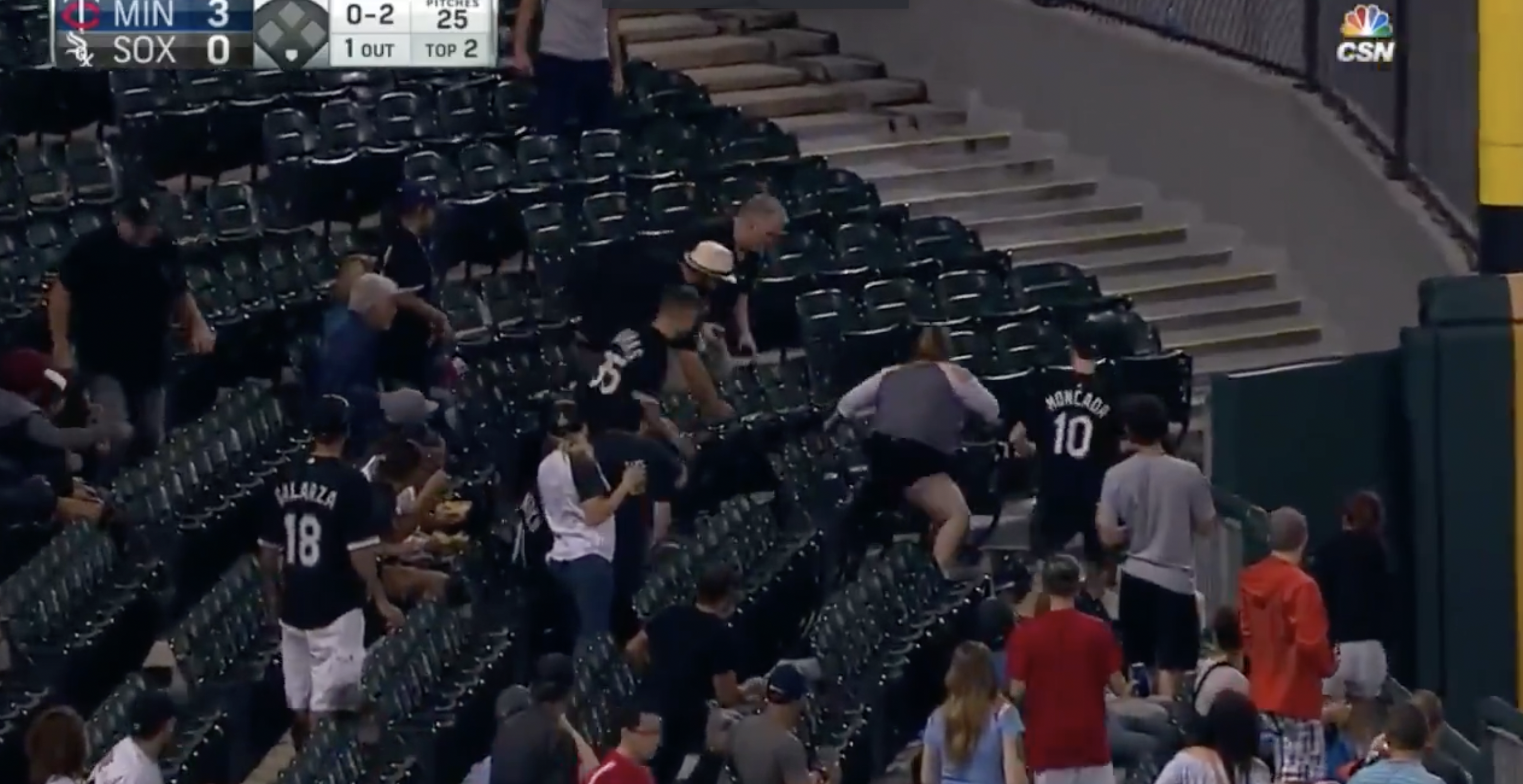 group of people trying to reach for a foul baseball at a game. 