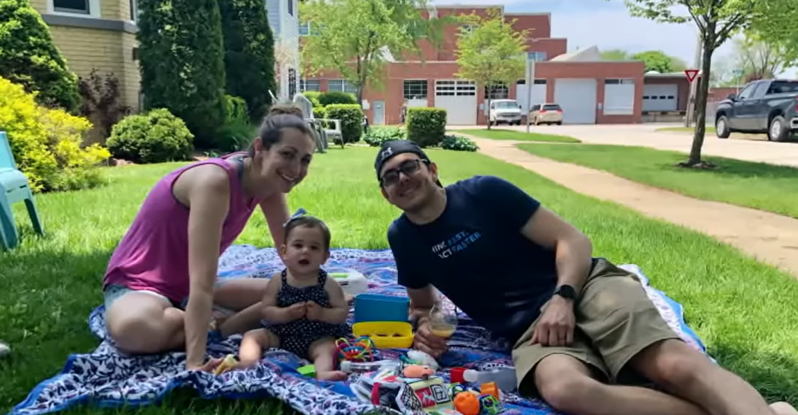Shelly Battista with her daughter and husband having a picnic outside.