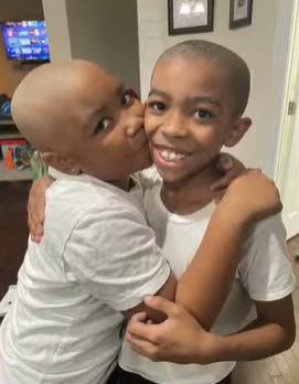 Carleigh Edwards kisses her brother on the cheek after he shaves his head in solidarity.