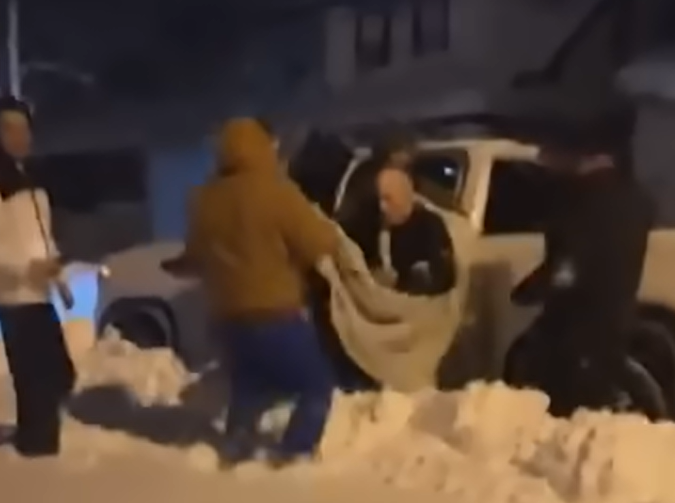 Good Samaritans helping Joe White into truck to go to hospital.
