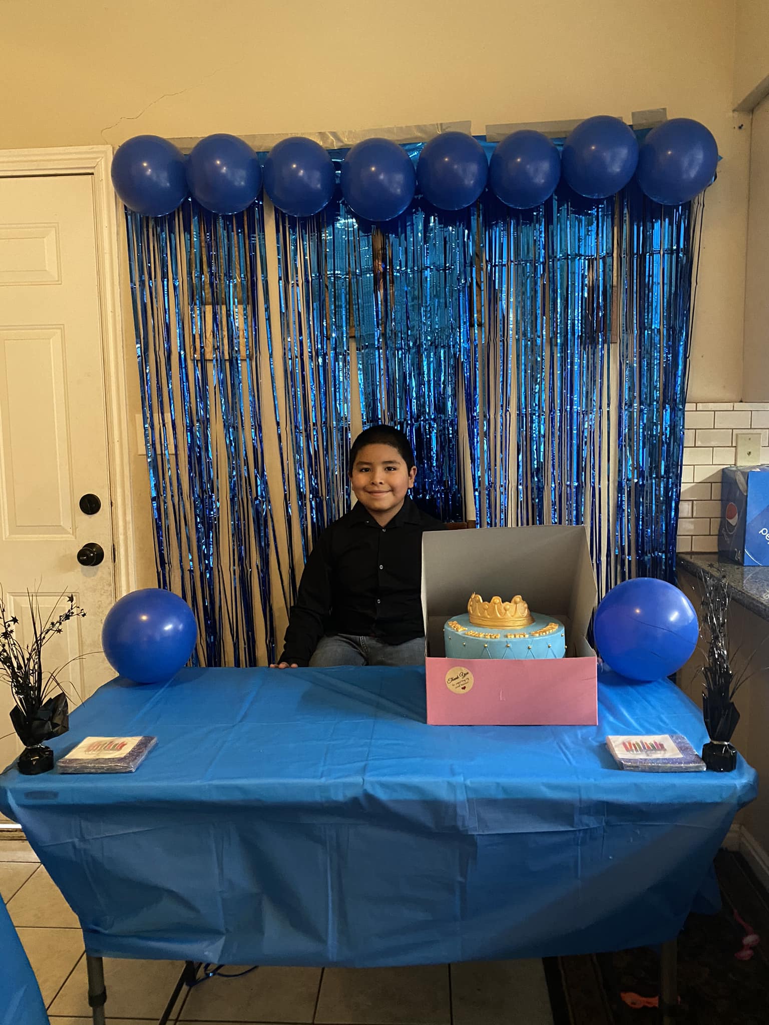 Jaydenn Lopez sitting with birthday cake on 9th birthday.