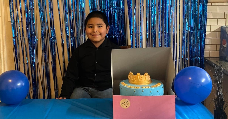 Jaydenn Lopez smiling with his cake on his 9th birthday