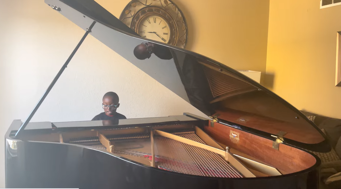Jude Nyame Yie Kofie playing his grand piano