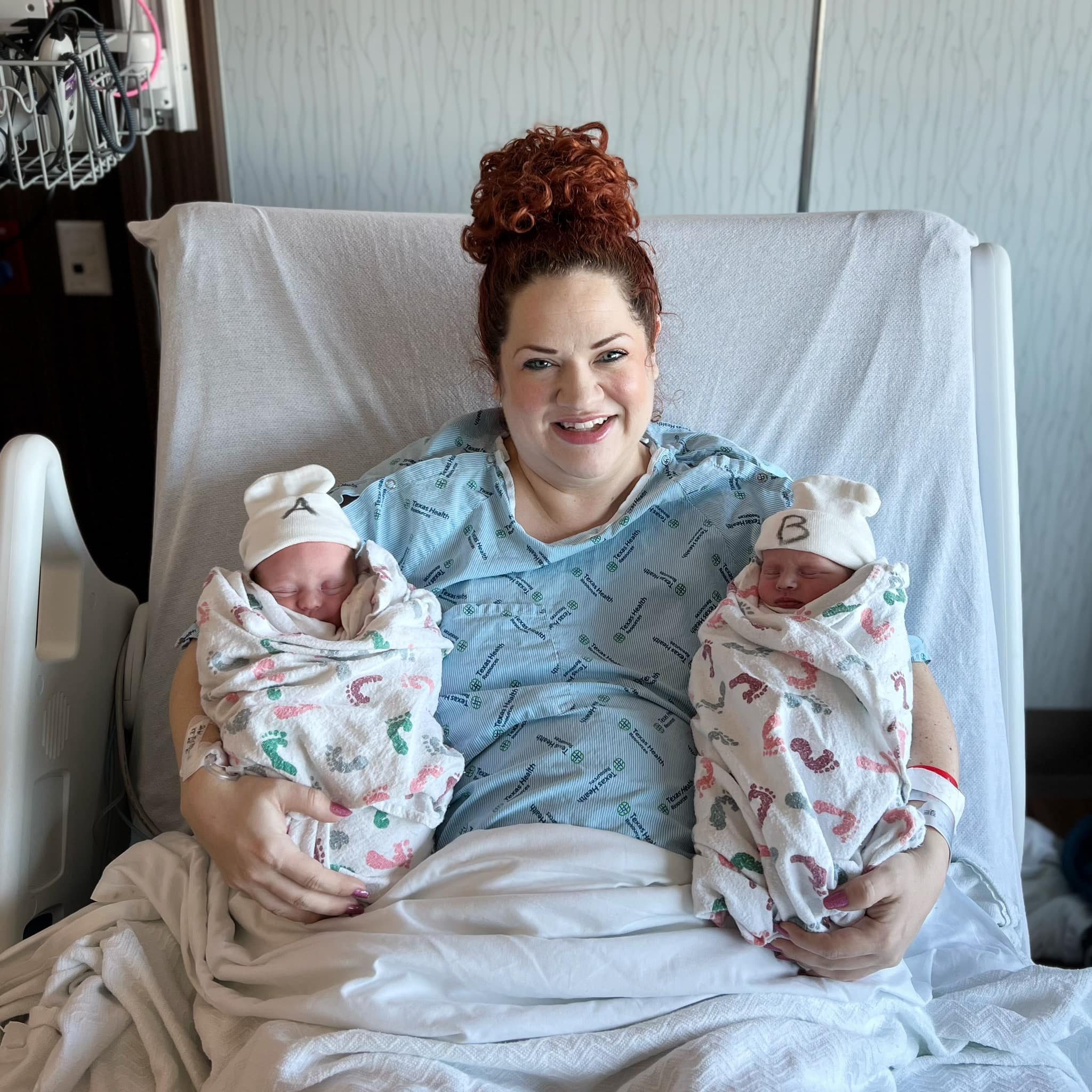 Kali Jo Scott holding her newborn twin daughters in the hospital.
