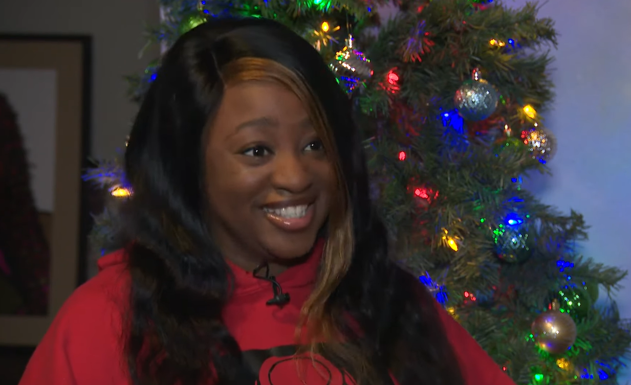 Kayla Howard smiling in front of a Christmas tree.