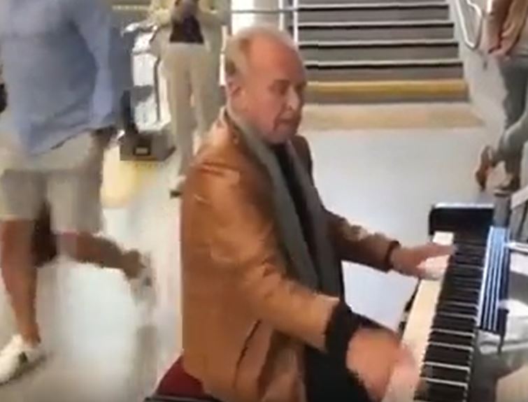 an dapper older man playing the piano enthusiastically