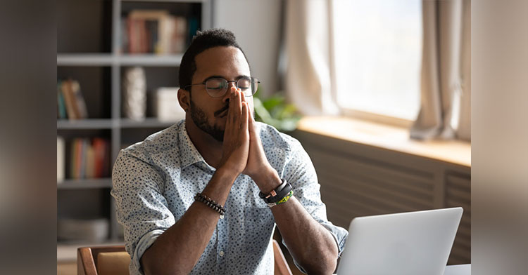 man thinking with eyes closed in a prayer pose