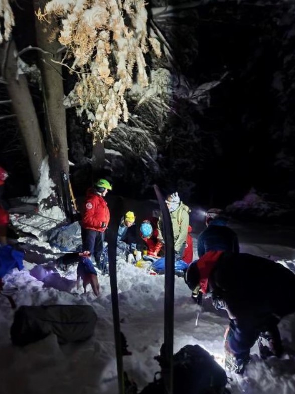 Group of rescuers work together to free the trapped skier.