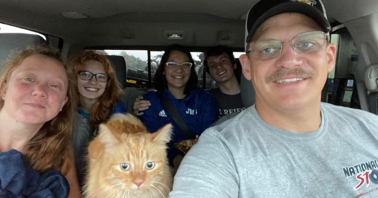 Delilah the stowaway cat in car with family