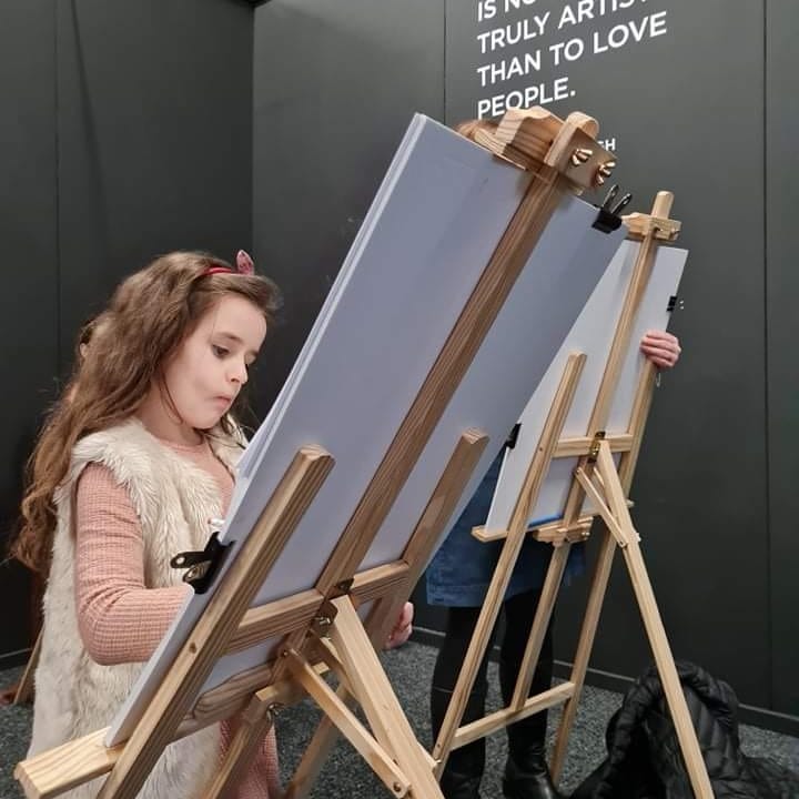 Edie painting on an easel 