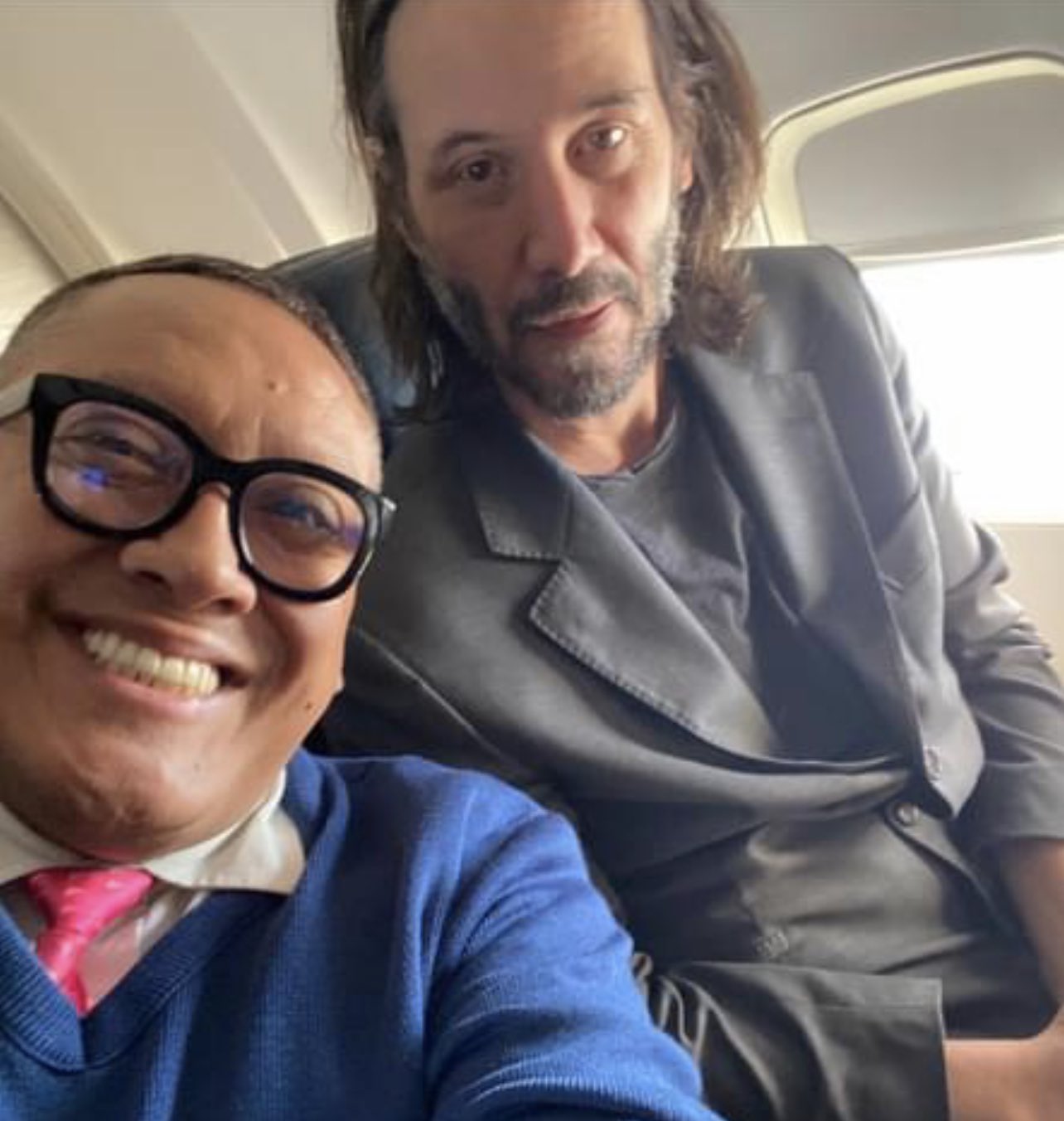 Keanu Reeves posing with fan on a plane