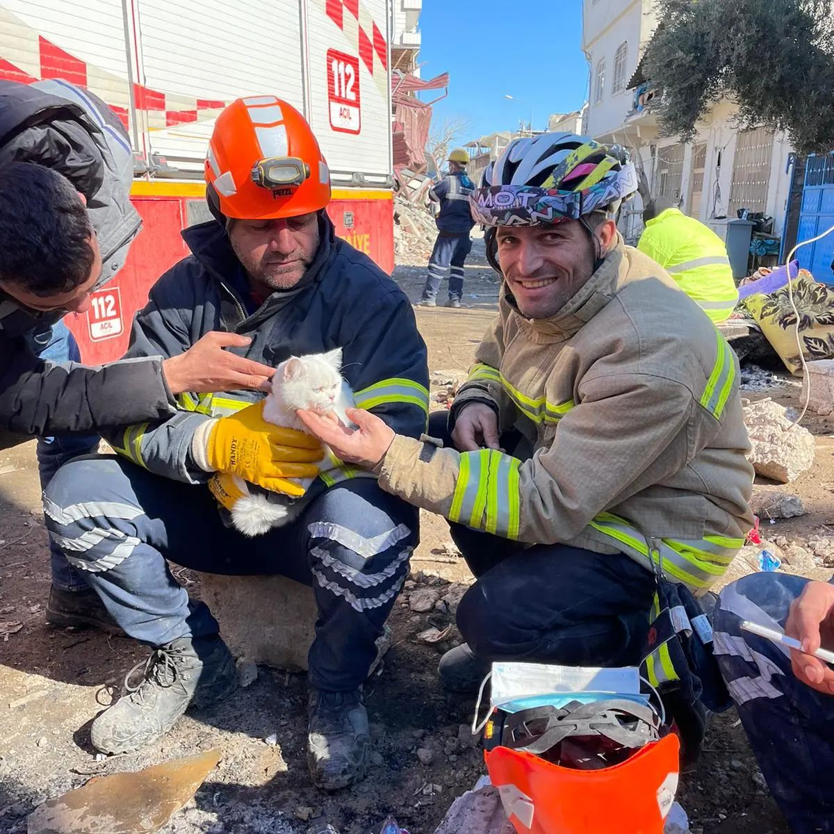 Ali Cakas and other firefighters holding kitten pulled from wreckage of earthquakes in Turkey.