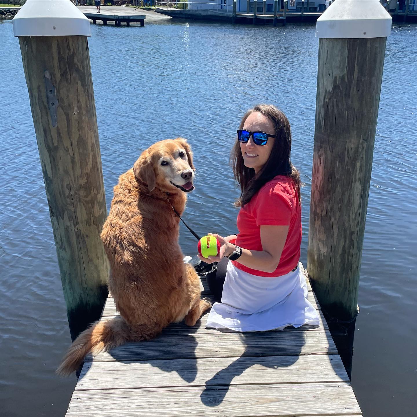 Ashley Liberto with Bentley sitting on a dock by the water