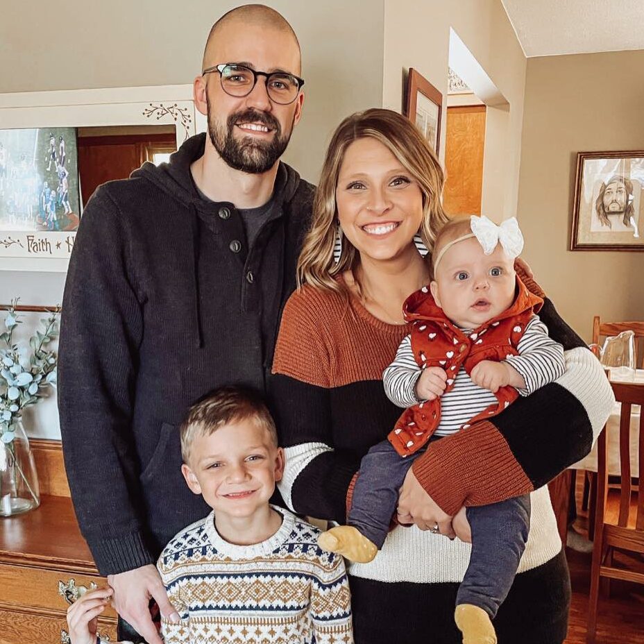 Coach Leland Schipper smiling with his wife and two children