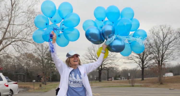 Mae Dean Erb waving balloons after running 1000 days in a row