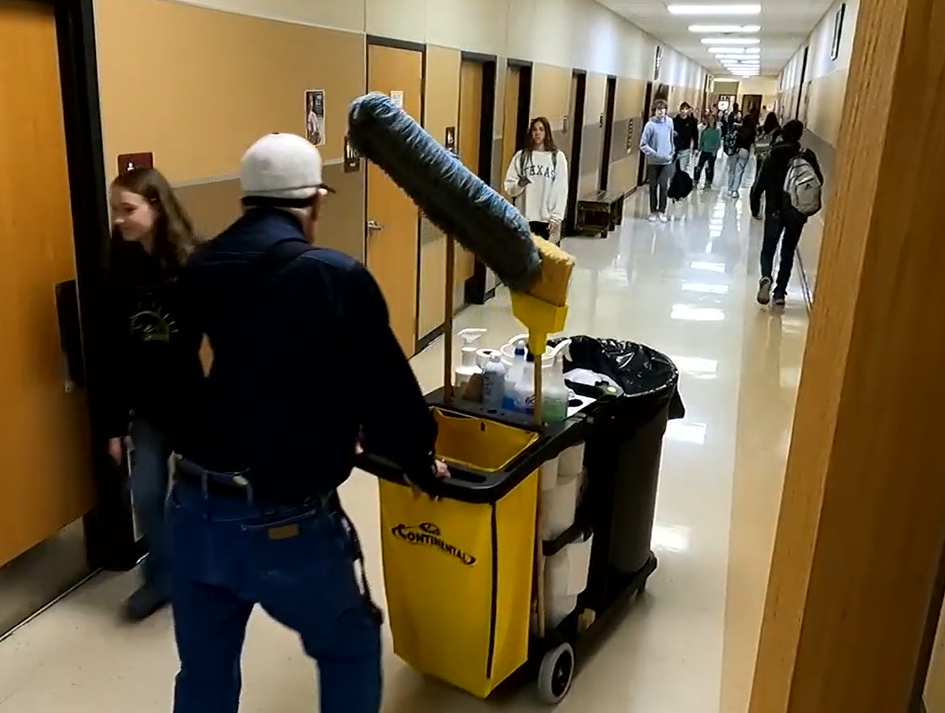 Mr. James pushing his janitor cart through the high school hallways