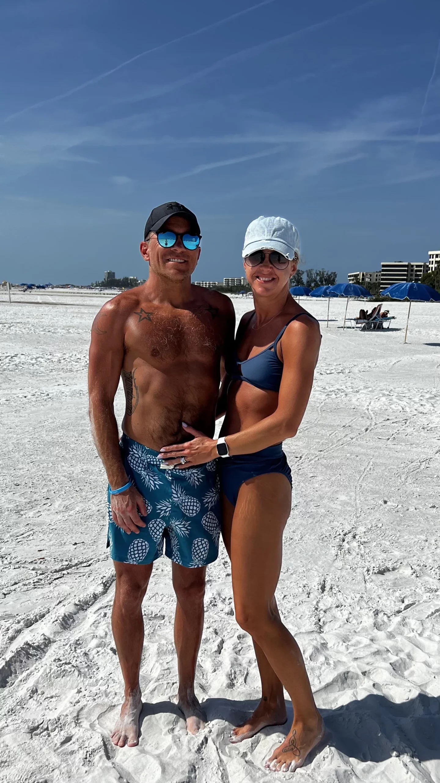 middle aged couple wearing swimsuits on the beach