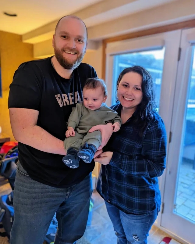 young couple smiling with new baby son.
