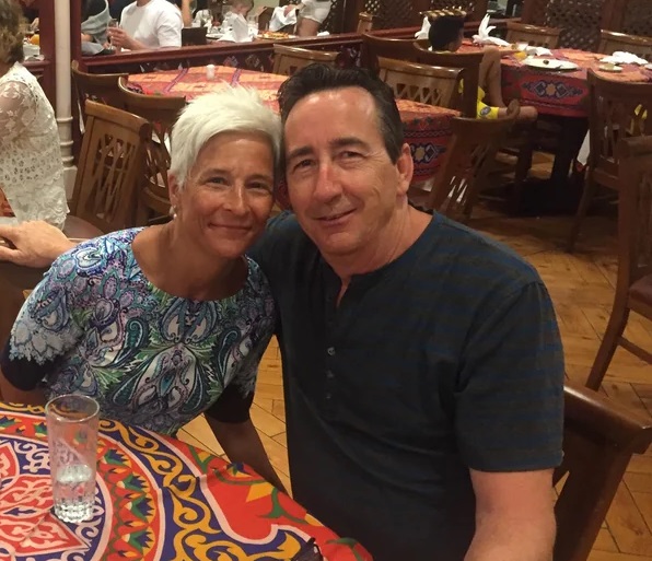 couple in their 50s smiling at a restaurant