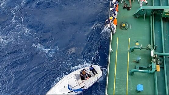 Crew members of the Silver Muna using cargo nets to hoist sailors lost at sea aboard.