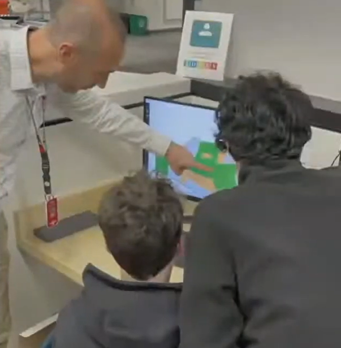 teacher pointing to screen while students look on