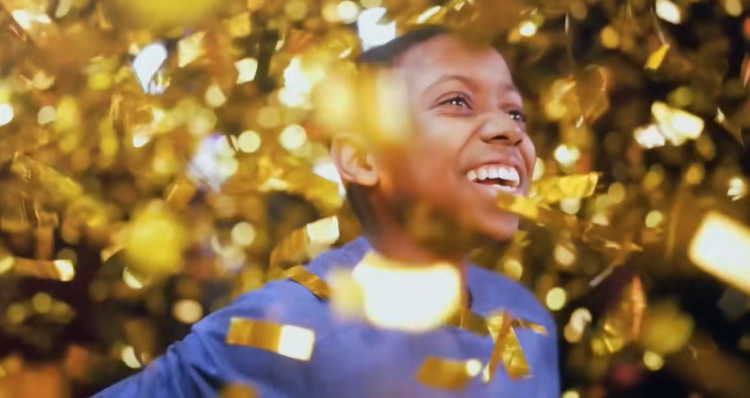 Malakai Boyah smiling as golden confetti floats around him on BGT