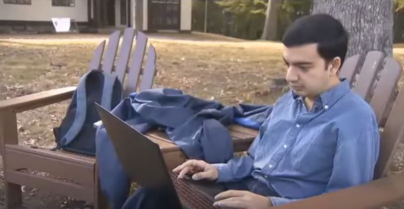 Sanmay using his laptop outside in lawn furniture
